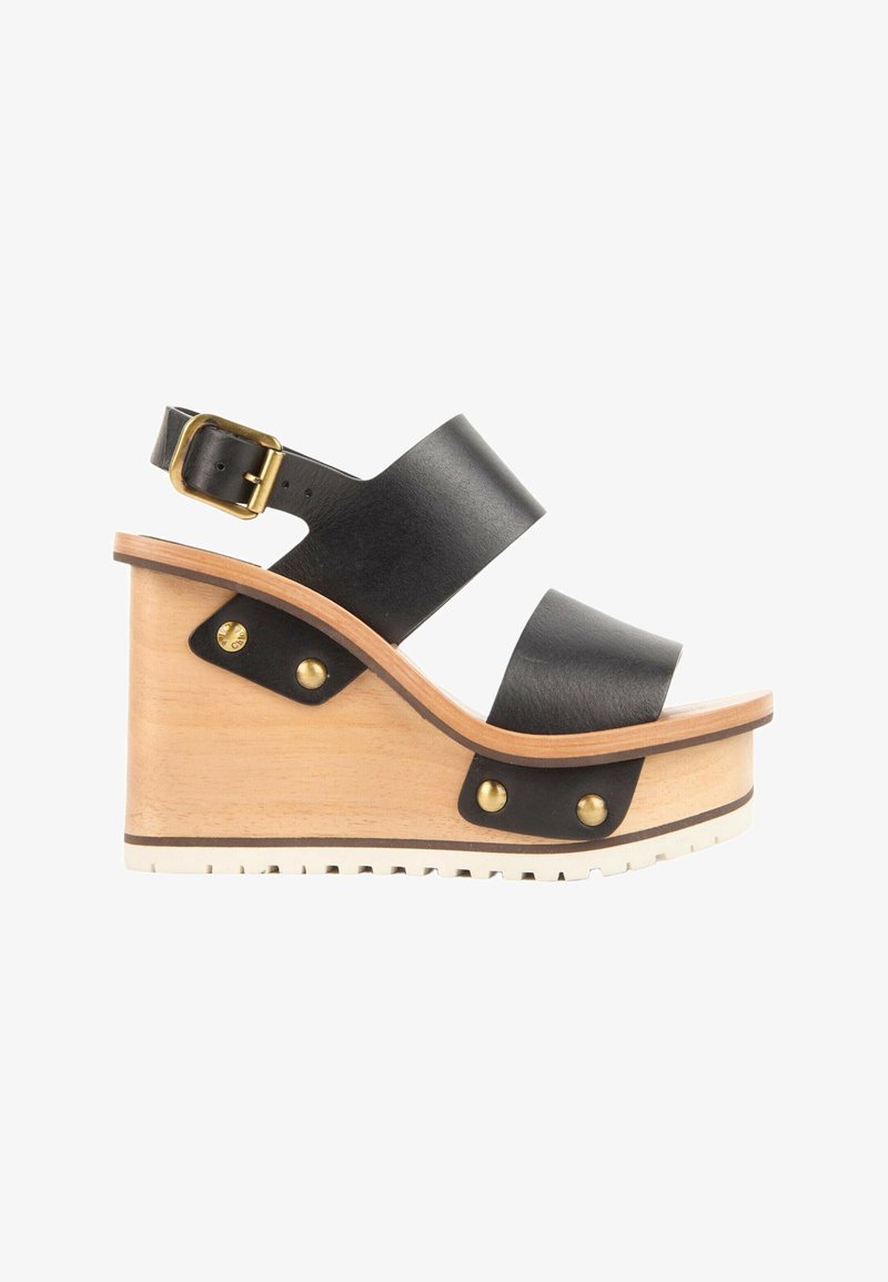Sandale compensée en cuir noir avec double brides, talon plateforme en bois, boucle dorée et rivets métalliques sur fond blanc.