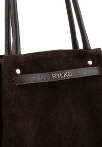 Hnědá semišová taška přes rameno s koženými uchy, texturovanou koženou nášivkou se značkou "RYŁKO" a zlatými kovovými akcenty.