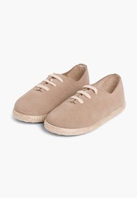 Espadrillas beige con tomaia in suede morbido, punta tonda e lacci crema. La suola avvolta in juta aggiunge texture e un aspetto naturale.