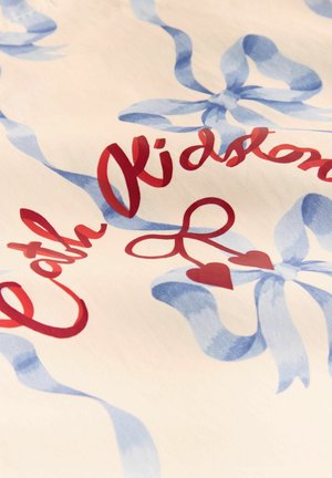 Krēmīgas auduma ar zilu lentas rakstu un sarkaniem burtiem "Cath Kidston" ar sirds akcentu un loku detaļām.