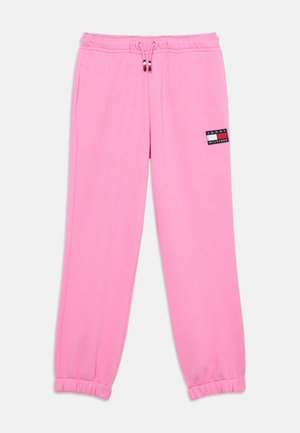 Różowe spodnie dresowe z elastycznym pasem i ściągaczami, sznurkiem z czerwonymi, białymi i niebieskimi końcówkami oraz małym logo Tommy Hilfiger na lewym udzie.