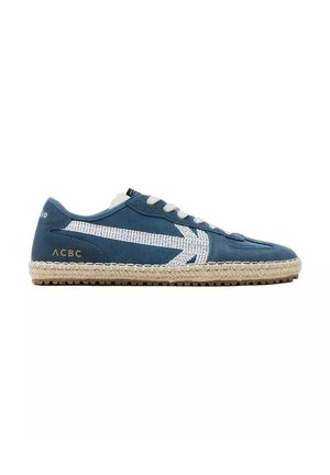Blauwe casual sneaker met een witte geweven streep, beige gevlochten zool, witte veters en gouden "ACBC" logo aan de hielzijde.