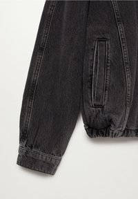 Black denim jacket sleeve with elasticized hem, featuring a side pocket and visible stitching details. Soft texture and relaxed fit.