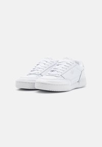 Witte leren sneakers met een laag ontwerp, voorzien van geperforeerde details, platte witte veters en een gestructureerde rubberen zool.