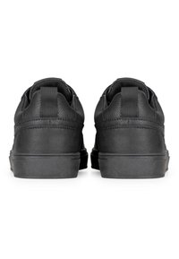 Las zapatillas de cuero negro presentan una superficie texturizada, un collar acolchado y una pestaña del talón reforzada. Suela de goma con patrón de agarre. Vista trasera.