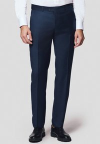Granatowe spodnie o dopasowanym kroju, gładkiej fakturze, prostym kroju i wyprasowanym zagięciu z przodu. W połączeniu z czarnymi eleganckimi butami.