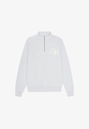 Svijetlo siva dukserica s patentnim zatvaračem na vratu, s rebrastim manžetama i donjim rubom, s vezom "L" i "D" loga na lijevoj strani prsiju. Mekana tekstura.