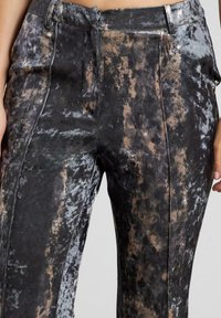 Texturierte, hochtaillierte Hosen mit einem schwarz-grau marmorierten Muster, einer glatten Oberfläche und vorderen Falten für zusätzliche Details.