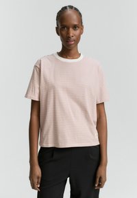 Maglietta a righe di colore rosa chiaro e bianco, collo rotondo con colletto a contrasto, maniche corte e tessuto morbido. Presenta un piccolo logo sull'orlo.