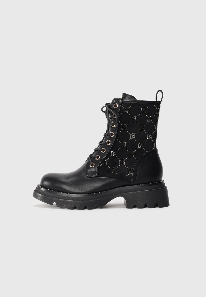 Zwarte veterschoenen tot de enkel met een glad leren teen en een gestructureerde, patroon-suède zijkant met hexagonale vormen en metallic accenten.