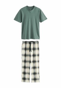 T-shirt en coton vert avec un col rond, associé à un pantalon en flanelle à carreaux blancs et noirs. Le pantalon présente une taille élastique et un cordon de serrage.