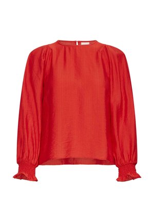 Blouse rouge à manches longues en tissu léger. Présente un col rond, des épaules froncées et des poignets élastiqués avec bords à volants.