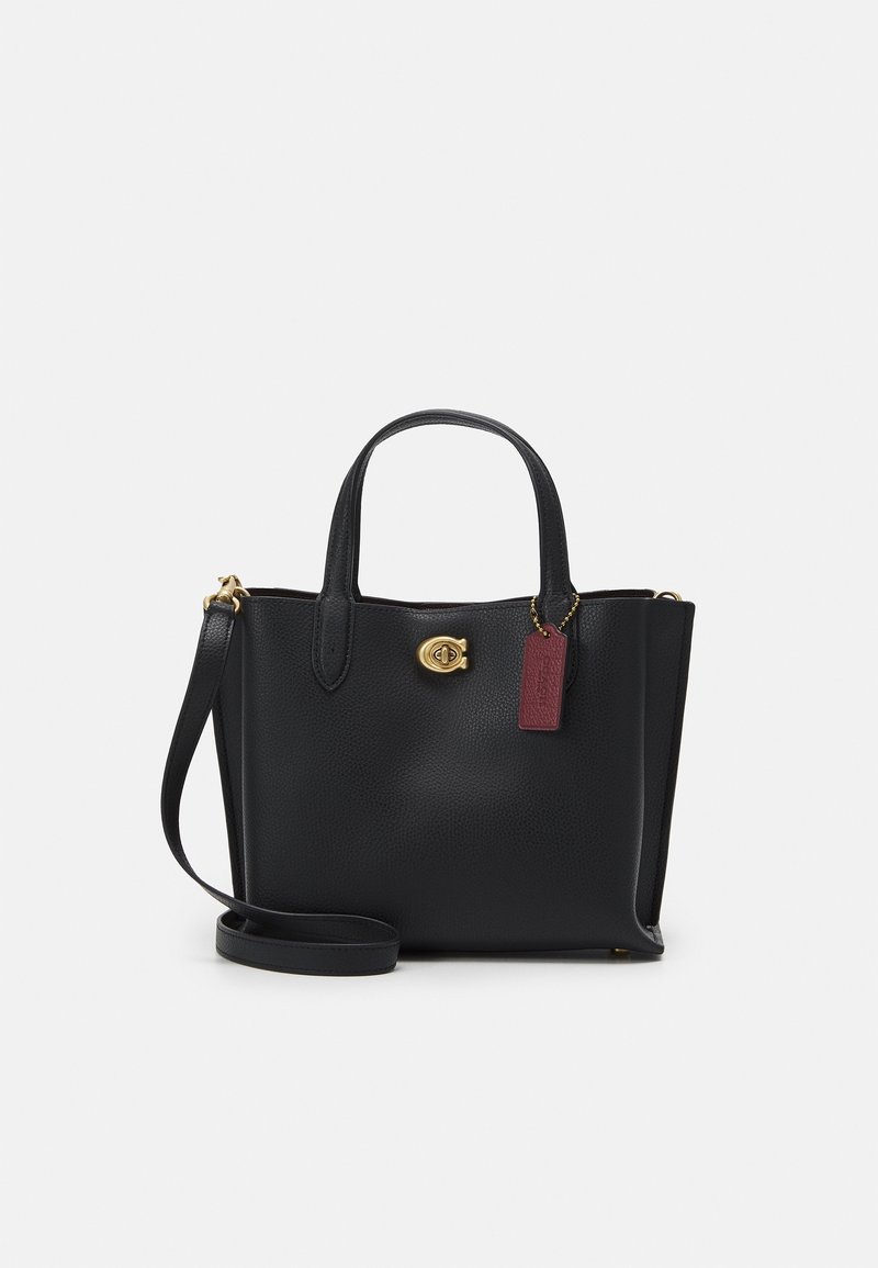 Black leather handbag with a textured surface, gold hardware, dual top handles, and a detachable strap. Features a red tag accent.