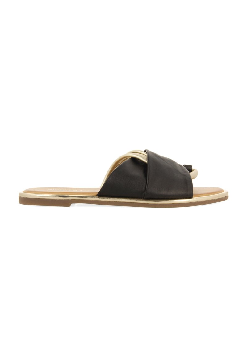 Chancla de cuero negro con diseño de tiras anudadas y un acento en tono dorado a lo largo de la suela. Suela plana, textura suave, estilo minimalista.