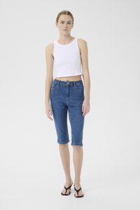 Denim bermuda kratke hlače v srednje modri barvi z zavihanimi robovi, petimi žepi in gumbom; v kompletu z belo brezrokavno kratko majico.