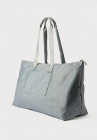 Világoskék utazótáska logómintával, textil anyagból, cipzáras zárással és két strapabíró fogantyúval. Elöl egy rakodó zsebe van.
