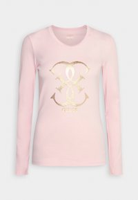 Ljusrosa långärmad t-shirt gjord av mjukt material med en metallisk guld grafisk logotyp i mitten och rundad halsringning.