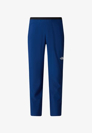 Pantalons de sport ajustés bleus avec une taille élastique noire et le logo The North Face sur la cuisse droite, vue de face.