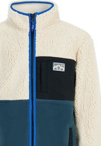 Fleece jacket featuring a cream, black, and teal color block design, high collar, and zip closure; includes a logo patch on the chest.
