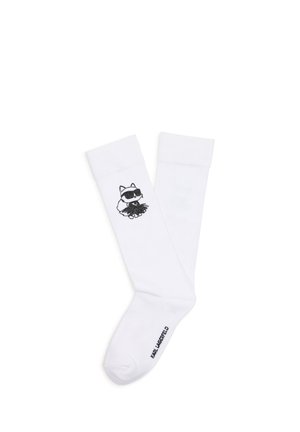 Chaussettes blanches hautes jusqu’au genou avec un chat noir de dessin animé portant des lunettes de soleil sur le mollet et "KARL LAGERFELD" imprimé près des orteils.