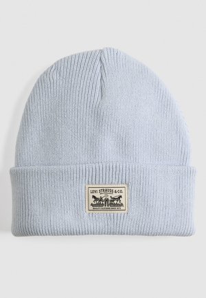 Gorro de punto azul claro con un dobladillo. Cuenta con una etiqueta de tela rectangular impresa con el logotipo de Levi Strauss & Co. y texto.