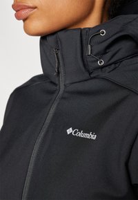 Black soft-shell jacket featuring a high collar, adjustable drawstring hood, and white Columbia logo on the left side.