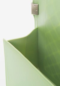 Borsa a mano in plastica verde con una superficie texturizzata, dotata di una chiusura metallica e un interno spazioso con una forma strutturata.