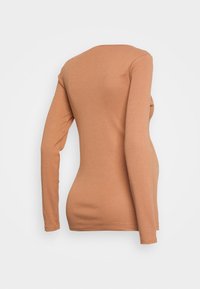 Camisola de mangas longas em um tom castanho claro, com um design ajustado. Feita de um tecido macio, apresenta um decote arredondado e textura lisa.