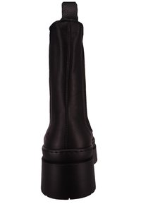 Bota de cuero negro hasta el tobillo con una textura suave, caña alta y una suela de plataforma gruesa. Cuenta con una lengüeta en la parte posterior y detalles de costura sutiles.