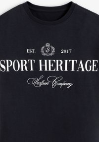 Camiseta de algodón azul marino con texto blanco: "HERENCIA DEPORTIVA", "EST. 2017" y "Scalpers Company." Diseño clásico de cuello redondo.