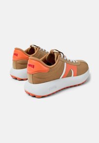 Sneaker marrone e arancione con tomaia in tela, accenti bianchi e una suola chunky bianca con dettagli in gomma arancione e lacci frontali.