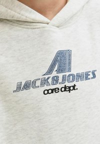 Grauer Kapuzenpullover mit Kapuze, weichem Material und einem blauen Grafiklogo mit "JACK & JONES" und "core dept." auf der Vorderseite.