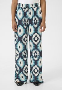 Tumedate voolavad püksid sinise ja kreemika geomeetrilise mustriga; elastne vöökoht koos paelaga; laiad sääred.