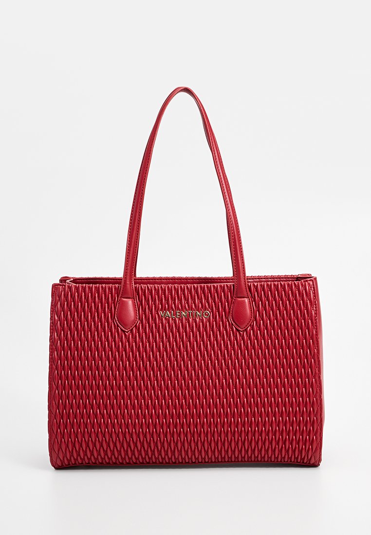 Sac fourre-tout en cuir rouge avec une texture matelassée, doté de deux longues poignées et d'un logo doré à l'avant. Forme rectangulaire, finition lisse.