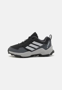 Black and gray hiking shoes with a mesh upper, reinforced toe cap, and textured rubber sole. Features three white stripes on the side.