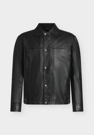 Veste en cuir noire à manches longues, fermeture par boutons-pression sur le devant, col classique, présentée sur un fond blanc uni.