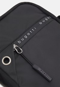Borsa in tessuto nero con superficie texturizzata, dotata di chiusura a zip, accessori in argento e logo stampato "bugatti". Design robusto e minimalista.