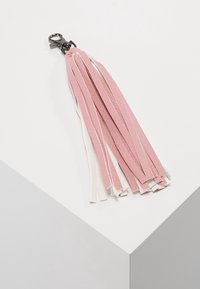 Portachiavi in pelle rosa e bianca con nappina e clip, composto da molteplici strisce di lunghezze diverse e una finitura testurizzata.