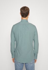 Green and white checkered long-sleeve shirt with a pointed collar, a straight back yoke, and buttoned cuffs, made of lightweight fabric.