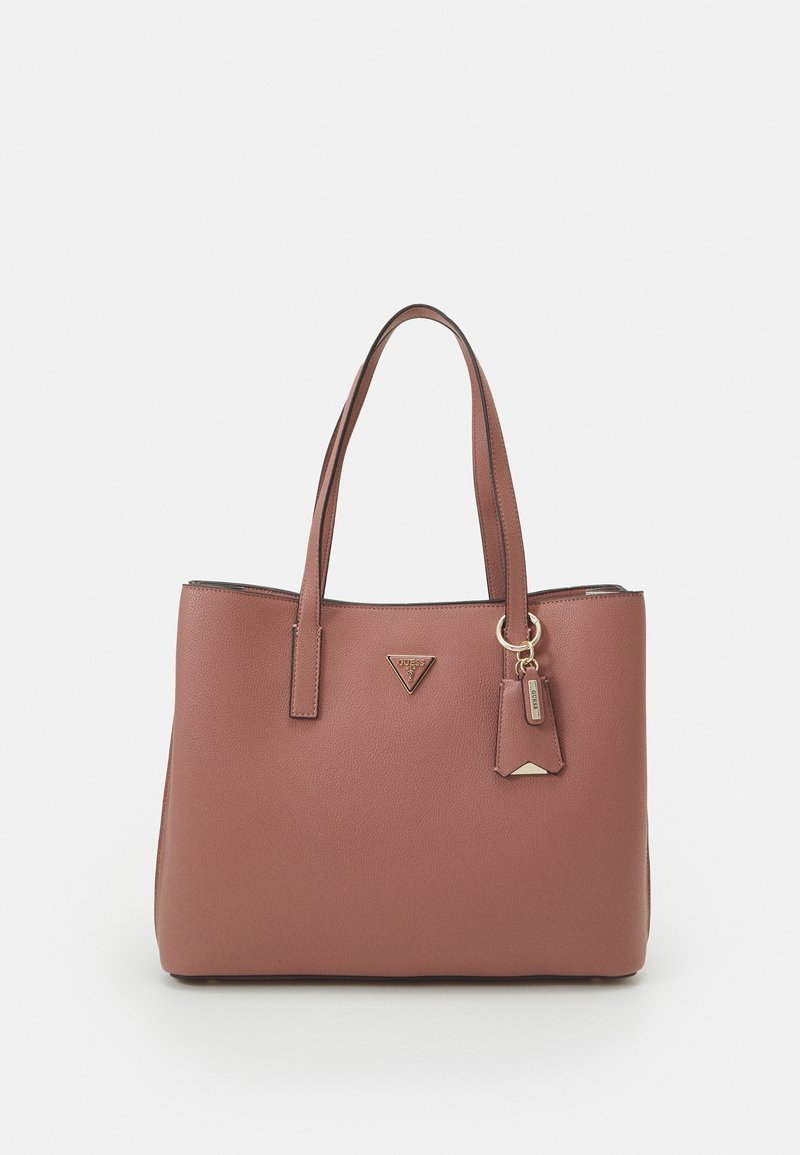 Sac fourre-tout en cuir marron avec deux bandoulières, logo métallique triangulaire, et une petite étiquette attachée avec des accents métalliques.