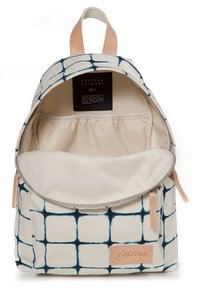 Sac à dos avec motif quadrillé tie-dye bleu, tirettes de fermeture éclair et poignée en cuir beige, compartiment principal ouvert et poche intérieure élastique.