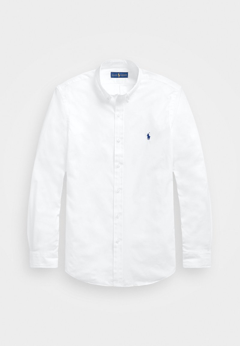 Camisa blanca de manga larga con botones, hecha de algodón, con cuello clásico, tapeta frontal y un pequeño logo azul en el pecho izquierdo.