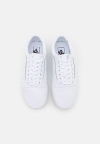 White canvas sneakers with a low-top design, round toe, and lace-up front. Features a textured upper and rubber sole.