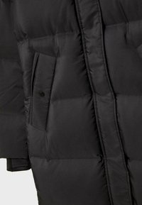 Černá prošívaná bunda s hladkou texturou, postranními kapsami a knoflíkovými detaily, zdůrazňující teplo a funkčnost.