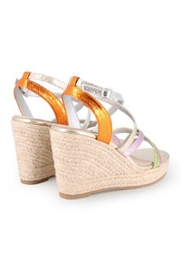 Sandalias de cuña con base de paja trenzada, que presentan tiras metálicas en naranja, plata, rosa y verde, con un cierre de hebilla.