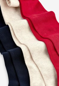 Cztery pary skarpetek w kolorze granatowym, kremowym i czerwonym. Zgniatany materiał pokazuje prążkowaną teksturę i miękki materiał, ułożony poziomo w nakładających się warstwach.