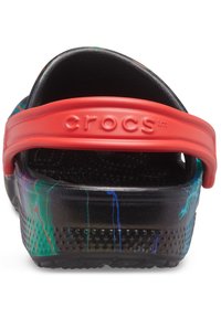 Rückansicht eines schwarzen Crocs-Clogs mit mehrfarbigem Spritzmuster und verstellbarem roten Fersenriemen, der mit dem Markennamen "crocs" geprägt ist.