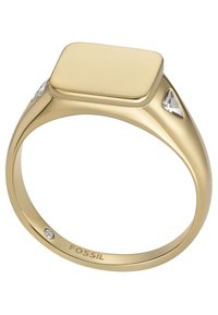Goldtonring mit quadratischer Oberfläche, der an den Seiten zwei dreieckige, klare Edelsteine aufweist und im Inneren des Rings "Fossil" eingraviert ist.