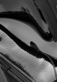 Schwarze Lacklederschuhe mit einer strukturierten, zerknitterten Oberfläche und einer glatten, abgerundeten Silhouette. Verfügt über einen seitlichen Reißverschluss und eine Gummisohle.
