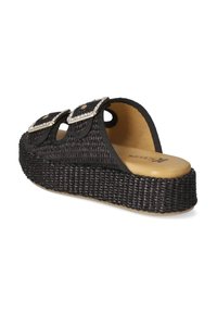 Sandale plateforme tissée noire avec fermetures à double boucle et accents de strass. Présente une semelle intérieure beige rembourrée et une semelle en caoutchouc texturé.